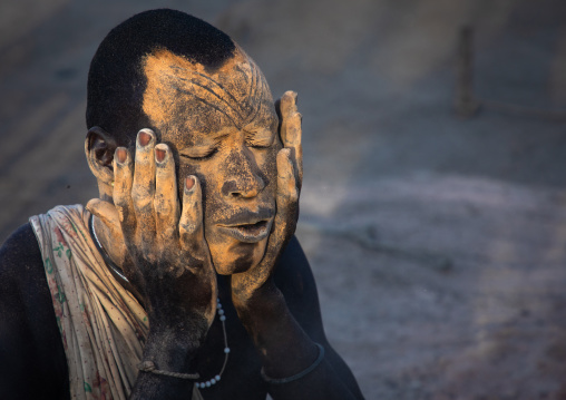 Mundari tribe man covering his body in ash to repel flies and mosquitoes, Central Equatoria, Terekeka, South Sudan