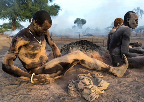 Mundari tribe men covering their bodies in ash to protect from the mosquitoes and flies bites, Central Equatoria, Terekeka, South Sudan