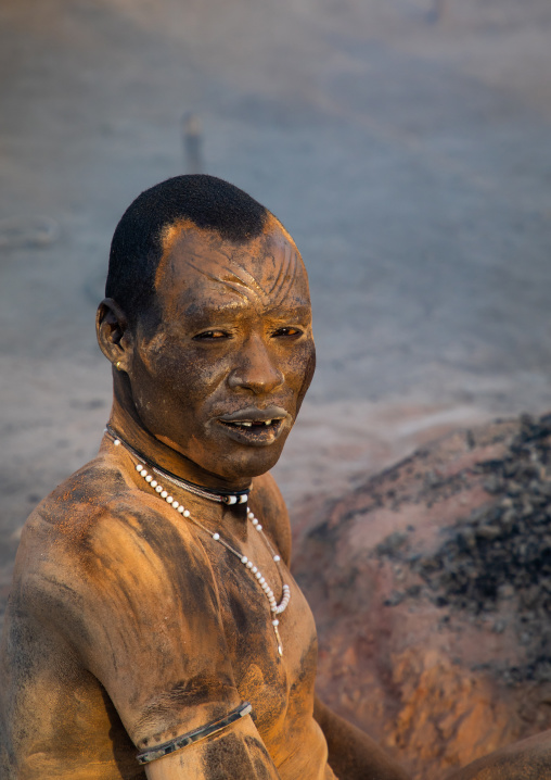 Mundari tribe man covering his body in ash to repel flies and mosquitoes, Central Equatoria, Terekeka, South Sudan