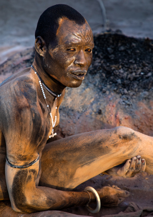 Mundari tribe man covering his body in ash to repel flies and mosquitoes, Central Equatoria, Terekeka, South Sudan