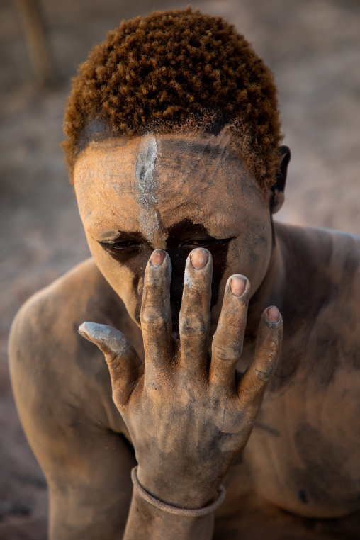 Mundari tribe man covering his body in ash to repel flies and mosquitoes, Central Equatoria, Terekeka, South Sudan