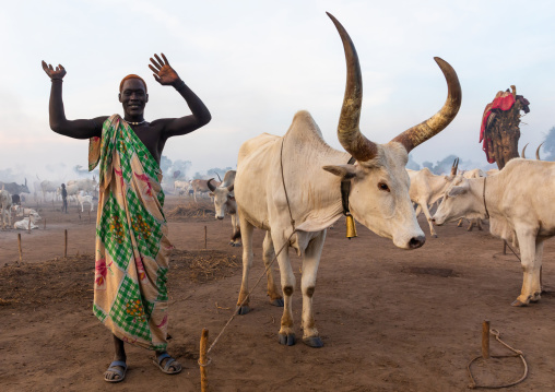 A Mundari tribe man mimics the position of horns of his favourite cow, Central Equatoria, Terekeka, South Sudan