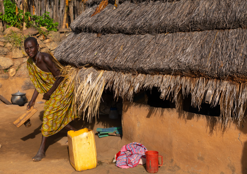 Lotuko tribe woman coming out from her thatched hut, Central Equatoria, Illeu, South Sudan