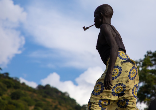 Lotuko trive woman smoking a pipe, Central Equatoria, Illeu, South Sudan