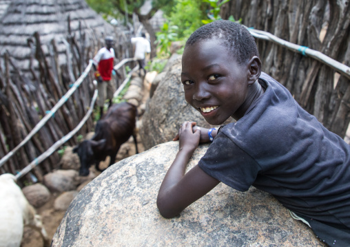 Boy looking at cows in a small alley of a Lotuko village, Central Equatoria, Illeu, South Sudan