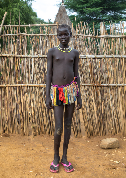 Larim tribe teenage girl in front of her traditional house, Boya Mountains, Imatong, South Sudan