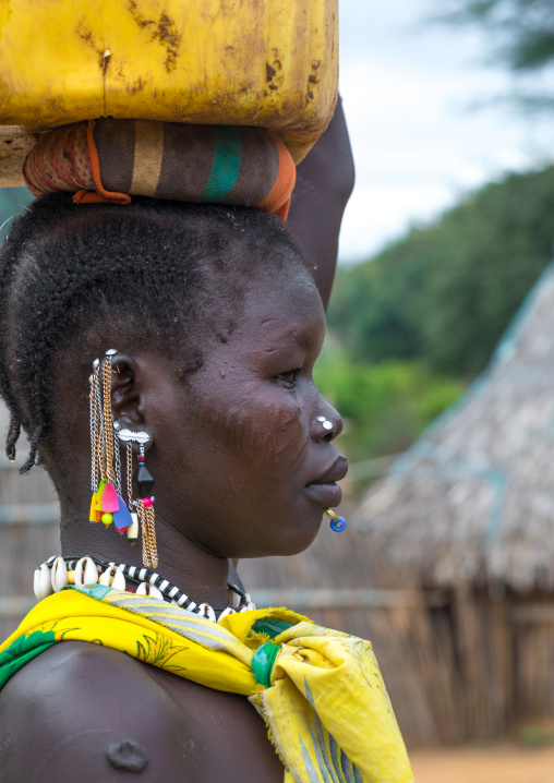 Portrait of a Larim tribe woman carrying a yellow jerrican on the head, Boya Mountains, Imatong, South Sudan