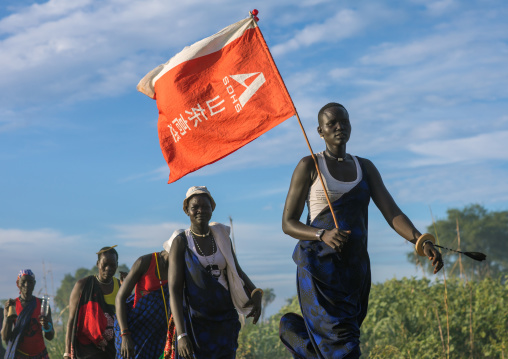 Mundari tribe women with a chinese flag celebrating a wedding, Central Equatoria, Terekeka, South Sudan