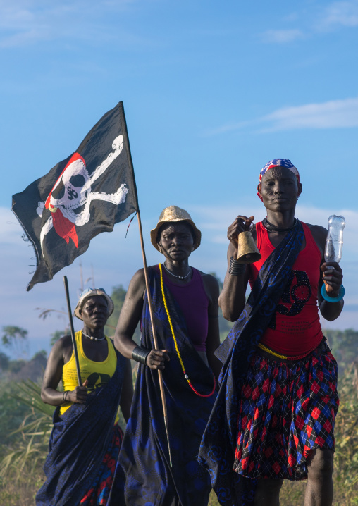 Mundari tribe women marching in line with a pirate flag while celebrating a wedding, Central Equatoria, Terekeka, South Sudan