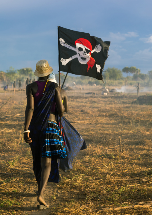 Mundari tribe women marching in line with a pirate flag while celebrating a wedding, Central Equatoria, Terekeka, South Sudan