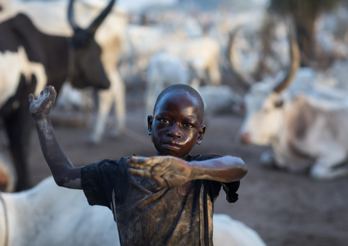 A Mundari tribe boy mimics the position of horns of his favourite cow, Central Equatoria, Terekeka, South Sudan