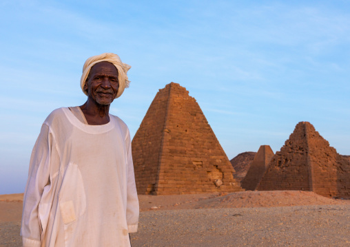 Old sudanese man in front of the meroitic pyramids of jebel Barkal, Northern State, Karima, Sudan