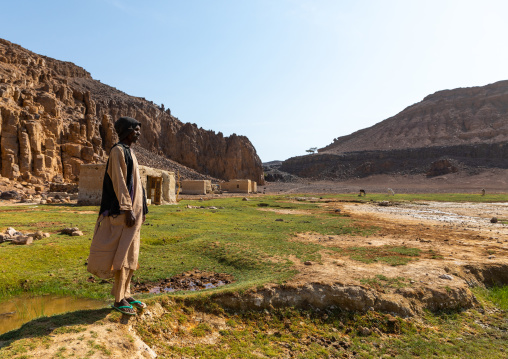 Bisharin nomad man collecting salt in Atrun crater, Bayuda desert, Atrun, Sudan