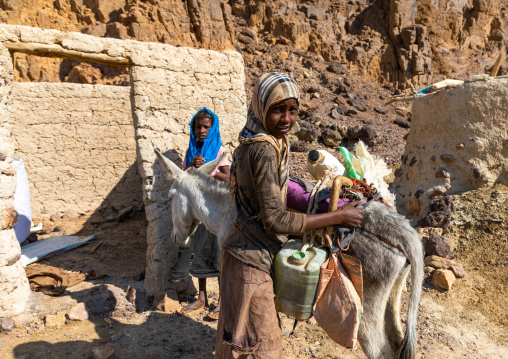 Bisharin nomad girls collecting salt in Atrun crater, Bayuda desert, Atrun, Sudan