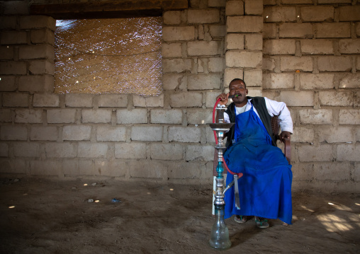 Beja man smoking water pipe, Red Sea State, Suakin, Sudan