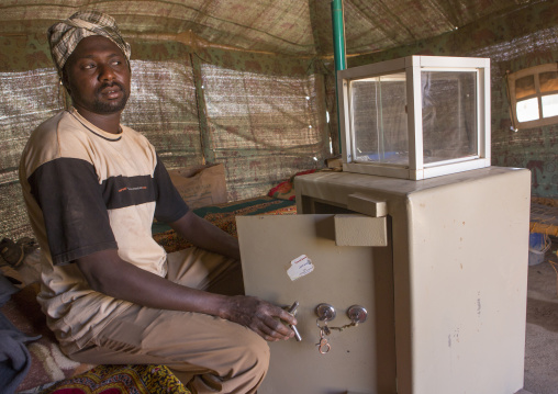 Sudan, Khartoum State, Alkhanag, man buying gold in front of his safety box