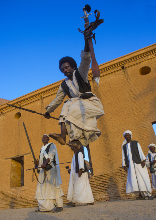 Sudan, Kassala State, Kassala, beja tribe men dancing in front of the khatmiyah mosque at the base of the taka mountains