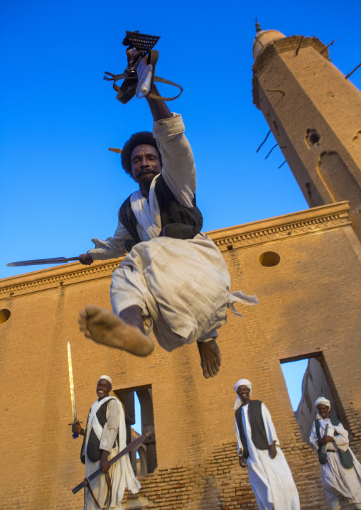 Sudan, Kassala State, Kassala, beja tribe men dancing in front of the khatmiyah mosque at the base of the taka mountains