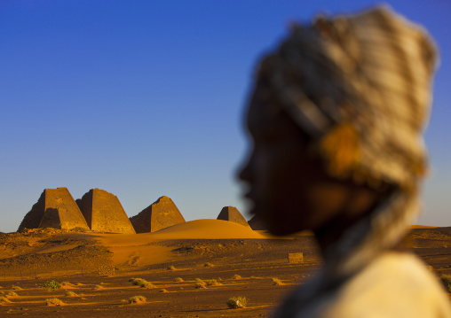 Sudan, Kush, Meroe, kid in front of the pyramids and tombs in royal cemetery