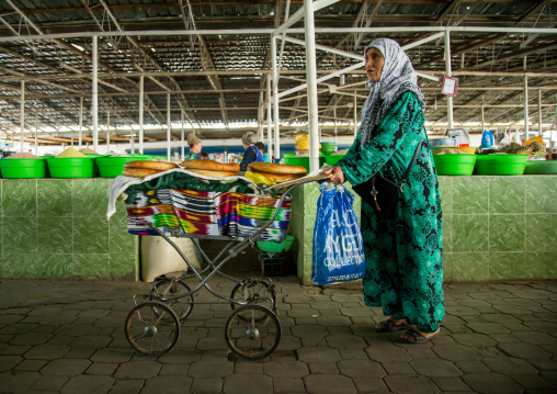 Old tajik woman selling some bread in a pram in a covered market, Gorno-Badakhshan autonomous region, Khorog, Tajikistan