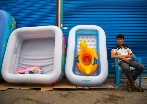 Tajik man selling plastic pools for children in the street, Gorno-Badakhshan autonomous region, Khorog, Tajikistan