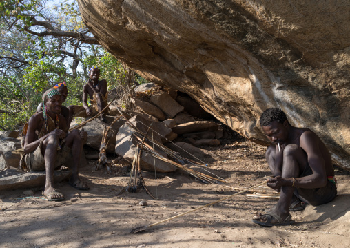 Tanzania, Serengeti Plateau, Lake Eyasi, hadzabe bushman making the arrow for a hunting bow