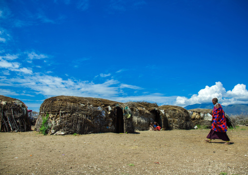 Tanzania, Ashura region, Ngorongoro Conservation Area, maasai cwoman passing in front oh her home