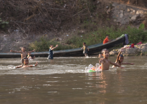 Children playing in the river of nam peang din village, North thailand