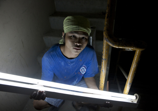 Construction worker with a neon light, Bangkok, Thailand