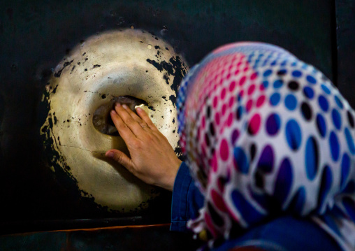 A tourist places her fingers in the wishing column and rotates her hand in Hagia Sophia, Sultanahmet, istanbul, Turkey