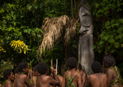 Women with grass skirts performing a Rom dance in front of a giant drum slit, Ambrym island, Olal, Vanuatu