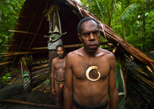 Portrait of chieftain Sekor and his father in front of a painted grade statue, Ambrym island, Olal, Vanuatu