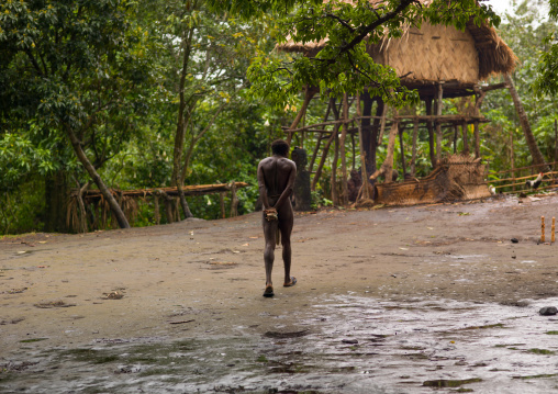 Ni-Vanuatu man walking under the rain in a village, Tanna island, Yakel, Vanuatu