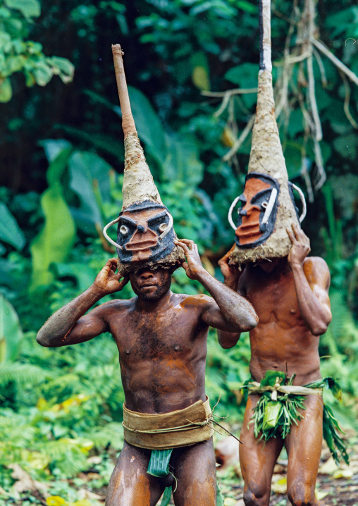 Tribesmen dancing in the jungle with helmet masks for a circumcision ceremony, Malampa province, Malekula island, Vanuatu