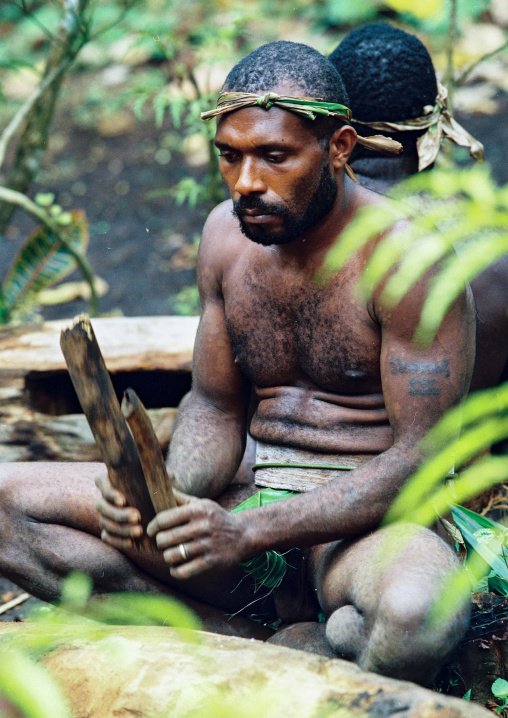 Tribesman beating a drum during a ceremony in the jungle, Malampa province, Malekula island, Vanuatu