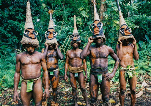 Tribesmen dancing in the jungle with helmet masks for a circumcision ceremony, Malampa province, Malekula island, Vanuatu