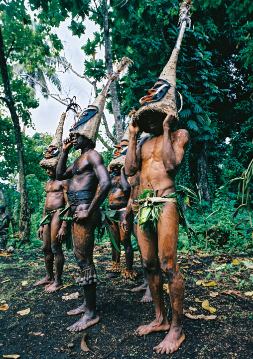 Tribesmen dancing in the jungle with helmet masks for a circumcision ceremony, Malampa province, Malekula island, Vanuatu