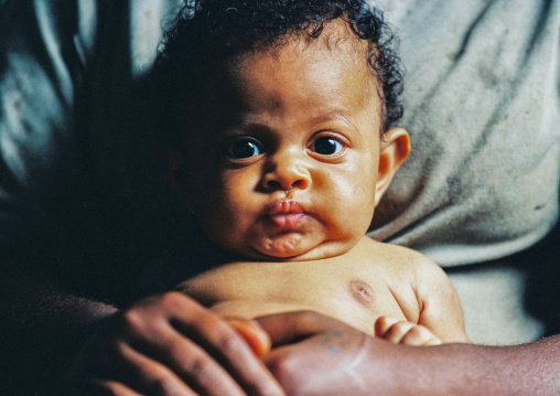 Portrait of a little boy resting in the arms of his mother, Malampa province, Malekula island, Vanuatu