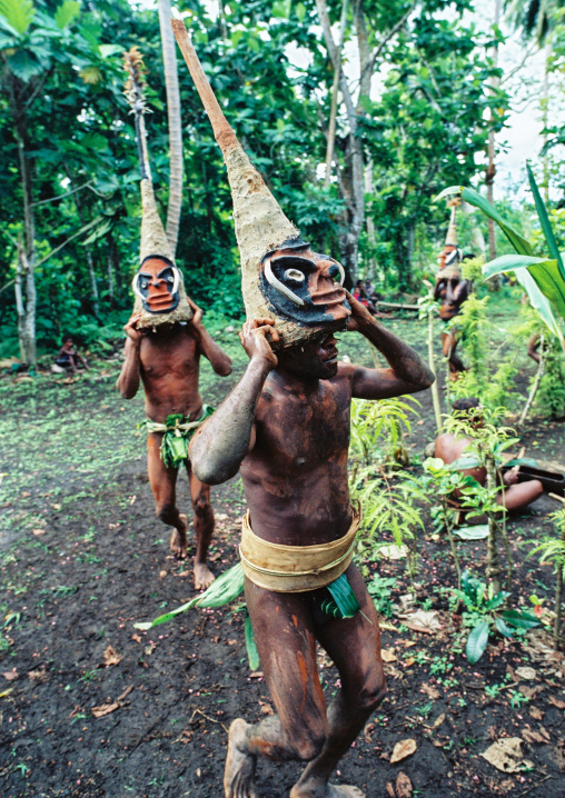 Tribesmen dancing in the jungle with helmet masks for a circumcision ceremony, Malampa province, Malekula island, Vanuatu