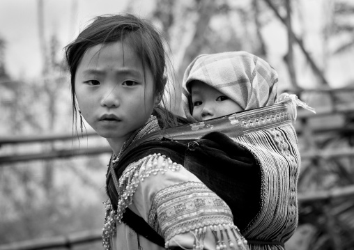 Flower hmong girl carrying her baby sister on her back, Sapa, Vietnam