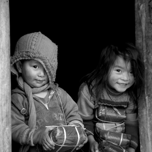 Black hmong kids holding wrapped rice cakes for tet, Sapa, Vietnam