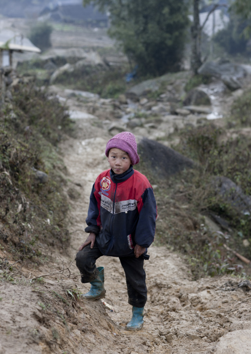 Black hmong boy with a woolly in a muddy path, Sapa, Vietnam