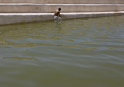 Man Taking A Bath In The  Water Cistern In The Mountain Village Of Hababa, Yemen