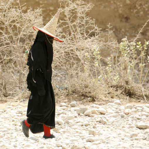 Hadramaut Woman Dressed In Black And Wearing A Cone Hat Passing By, Hadramaut, Yemen